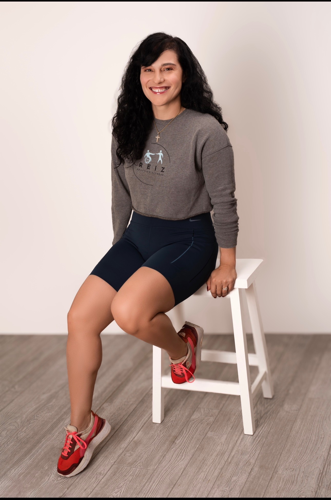 Head-and-shoulders portrait of Mziya Weber in a REIZ Adaptive Fitness sweatshirt