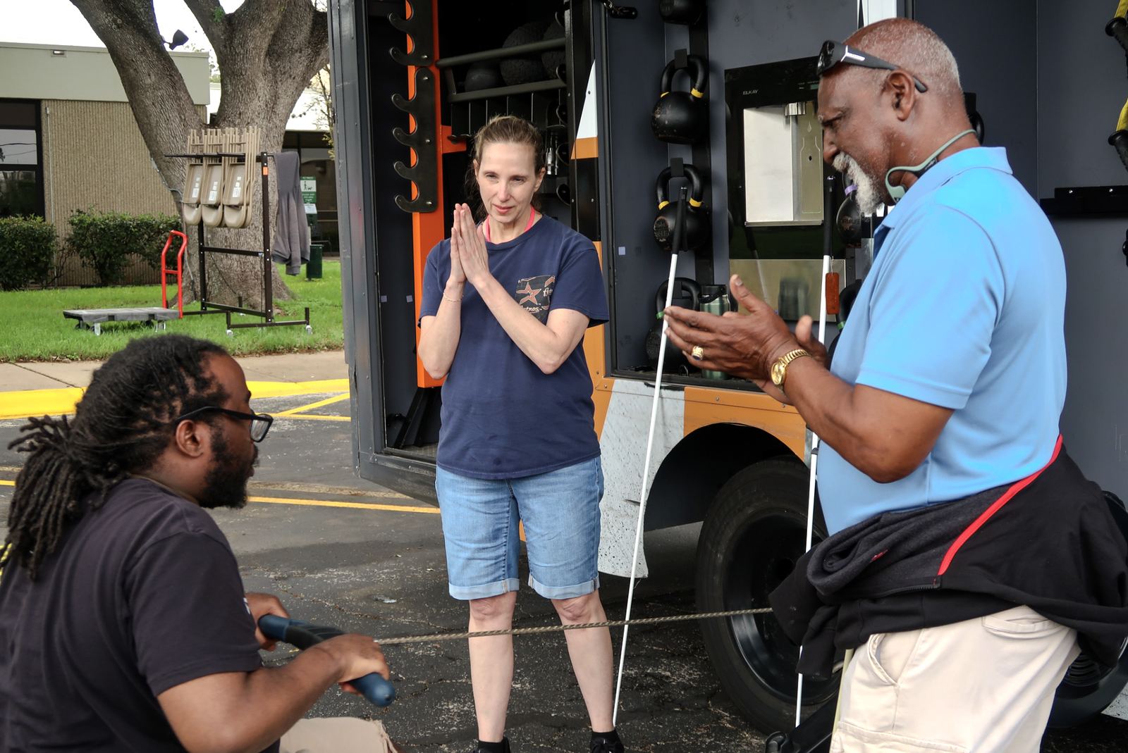 A coach talking with participants at the side of the mobile gym