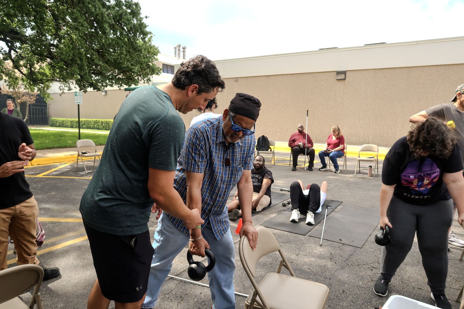 Participants lifting kettlebells together during an outdoor community session