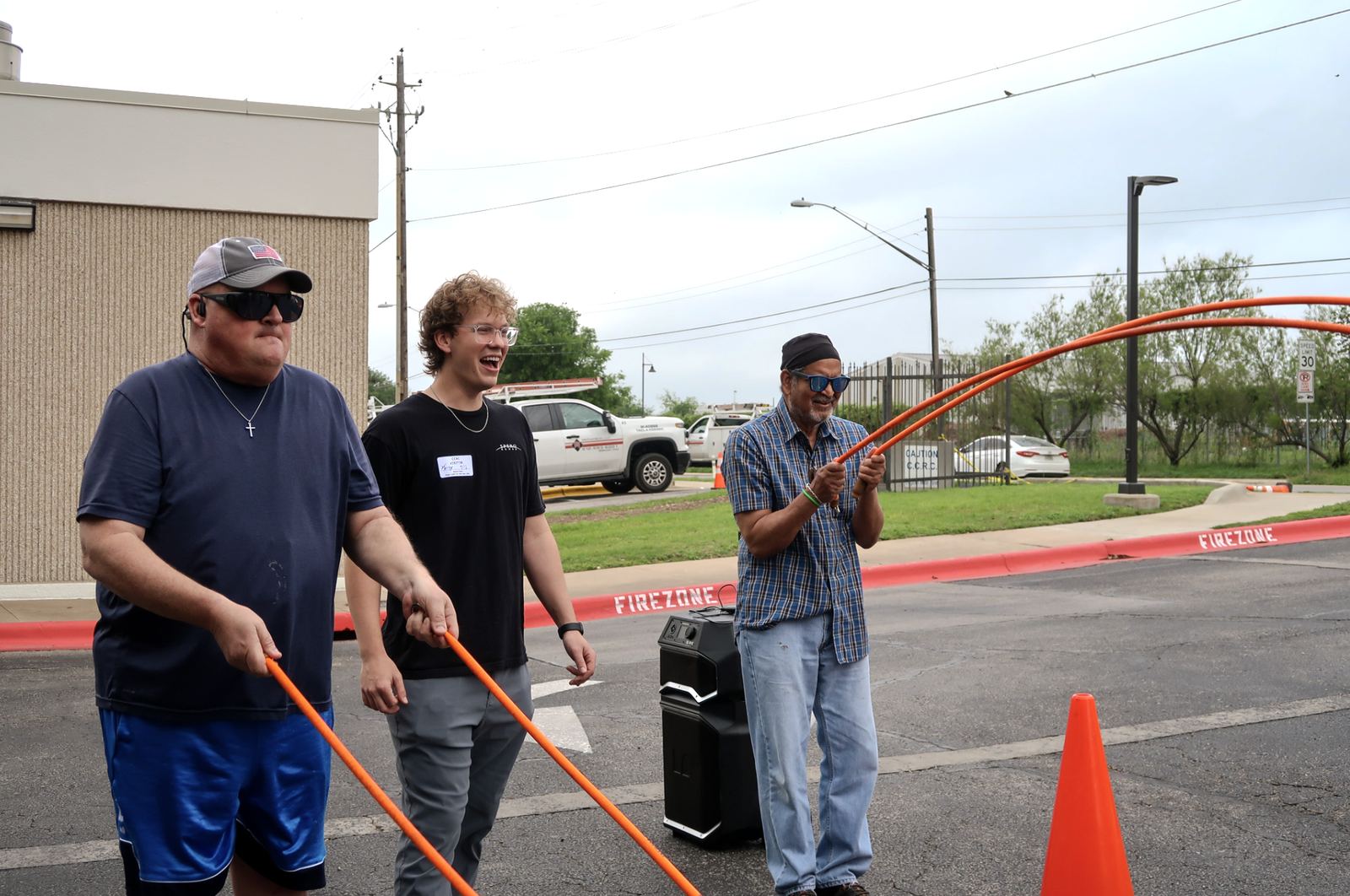 Participants smiling while training with battle ropes outdoors